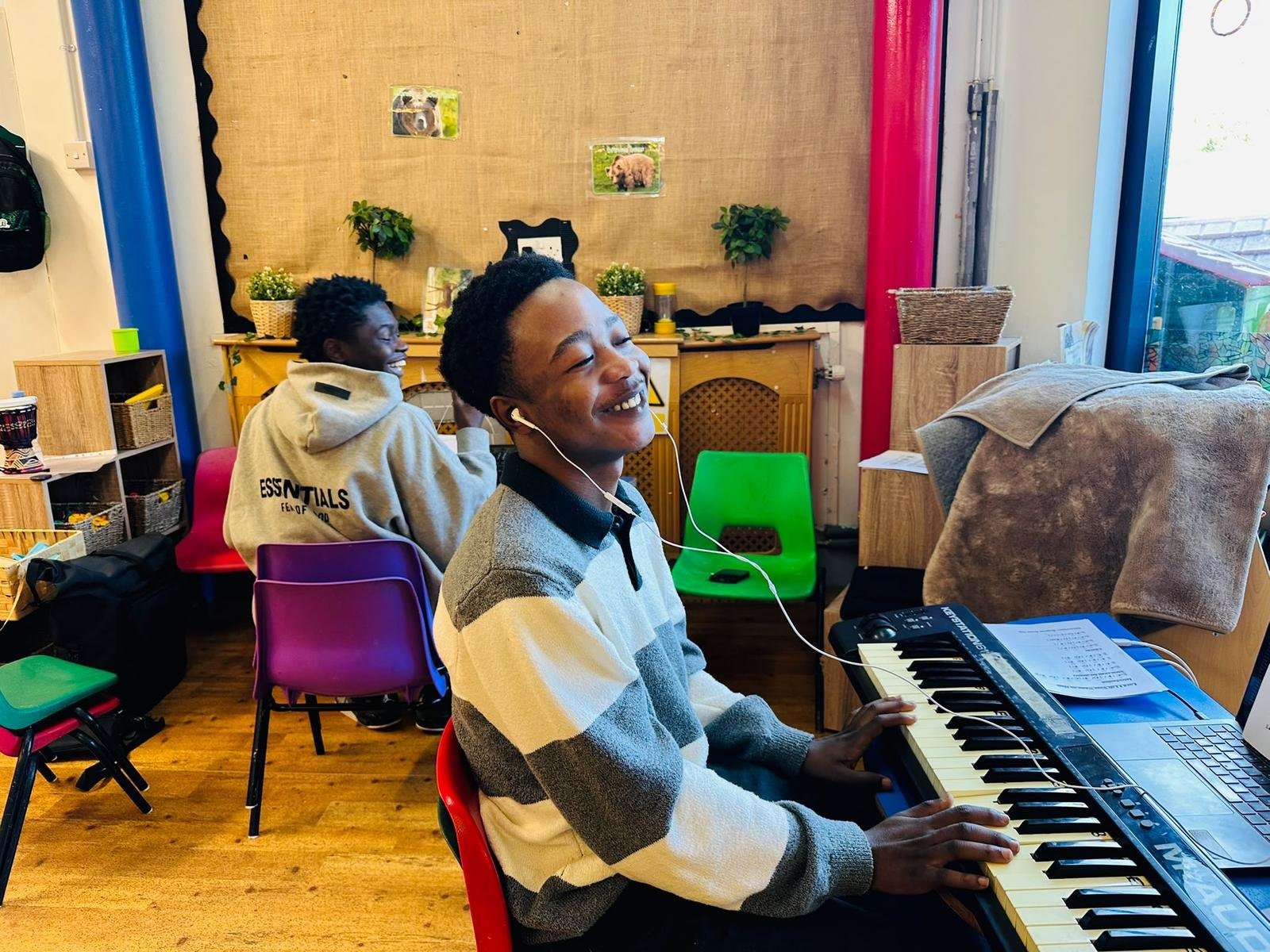 Two young people laughing together during a keyboard lesson at church